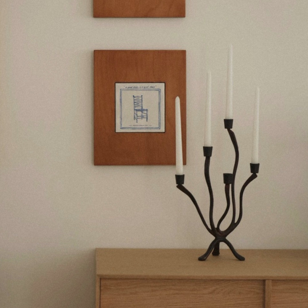 minimalist black candle holder on wood dresser in a neutral styled room