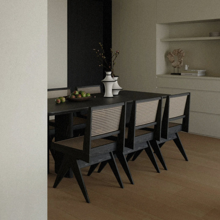 minimalist ceramic vases arranged on a dark dining table in a contemporary dining room with clean architectural lines.