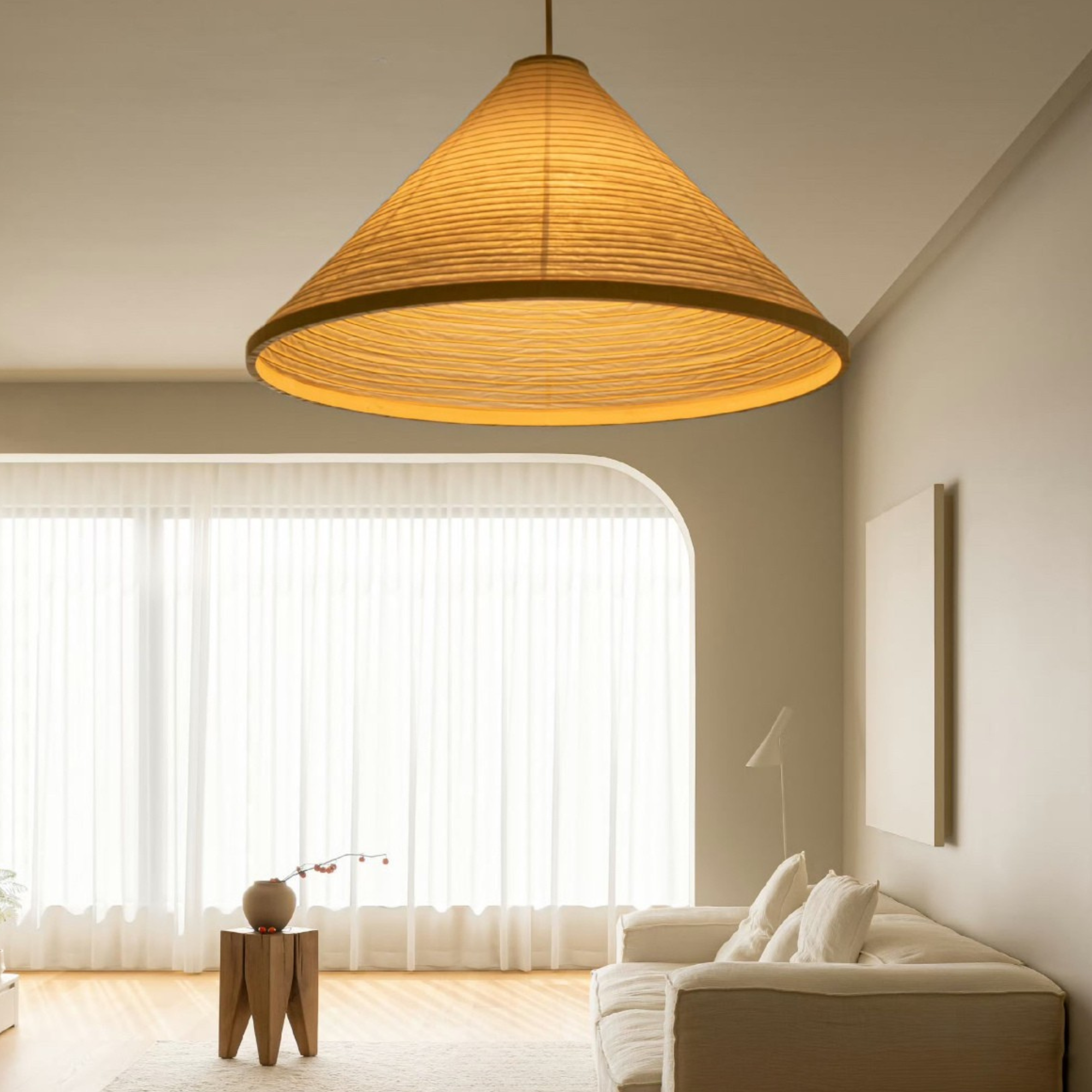 Minimalist cotton paper pendant lamp softly glowing in a modern living room with neutral tones.