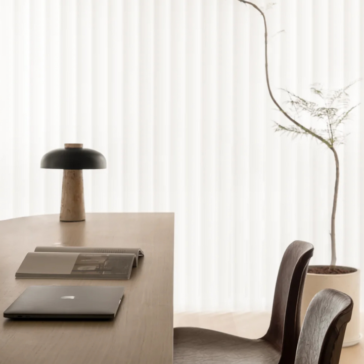 Minimalist design table lamp with a travertine base and black shade, enhancing the room's aesthetic.