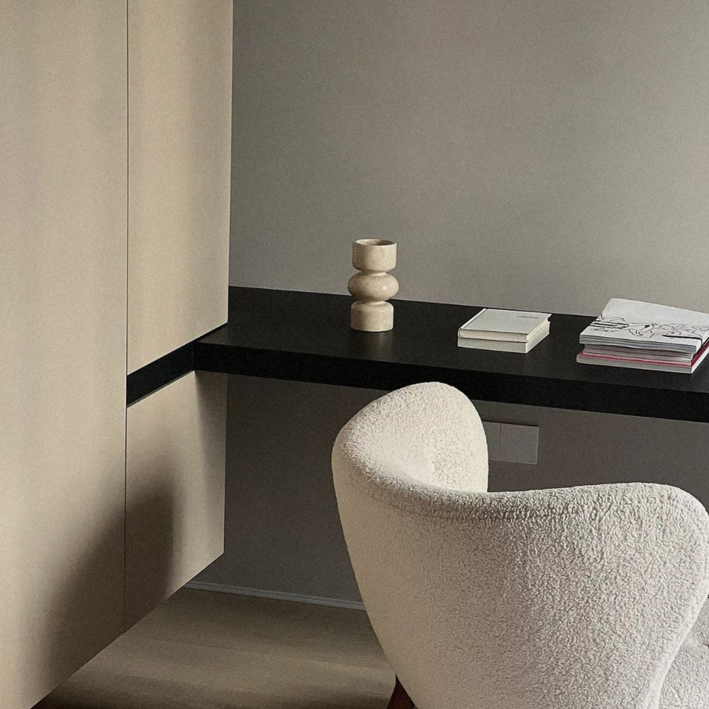 minimalist marble vase placed on a floating shelf in a neutral interior setting.
