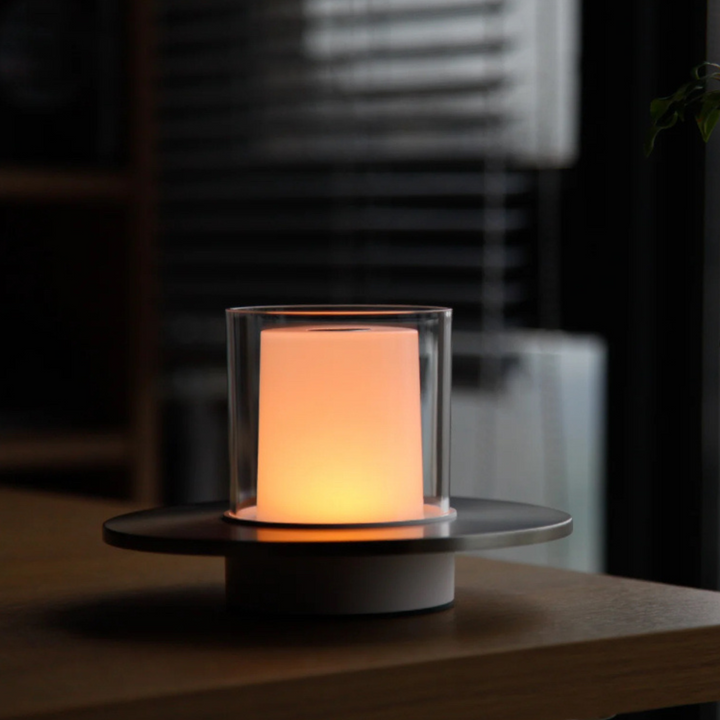 Minimalist touch-control candlelight lamp emitting a soft ambient light on a wooden surface.