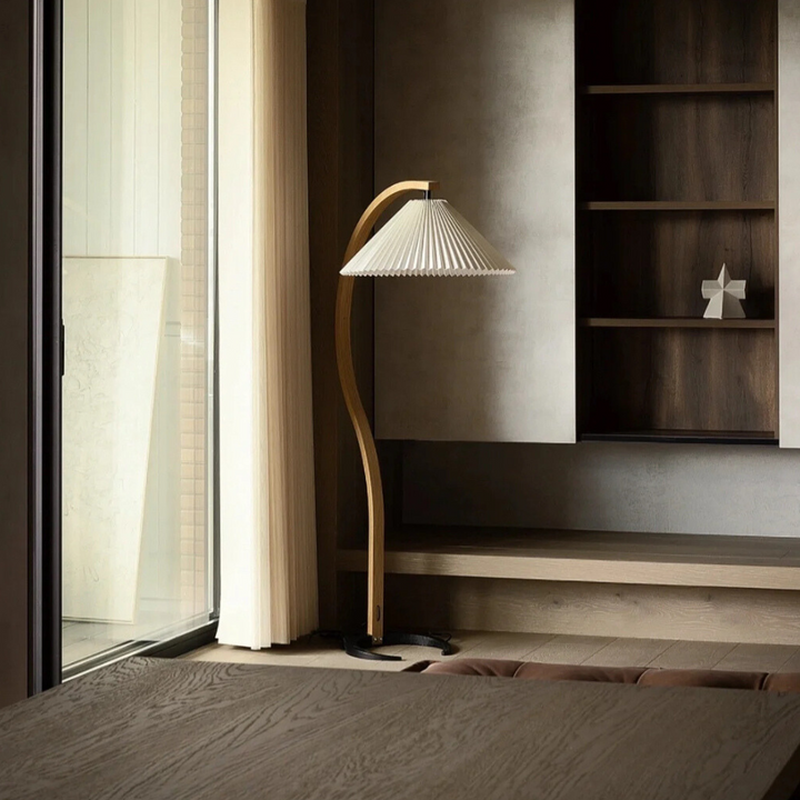 Minimalist wooden floor lamp in a serene reading nook with daylight.