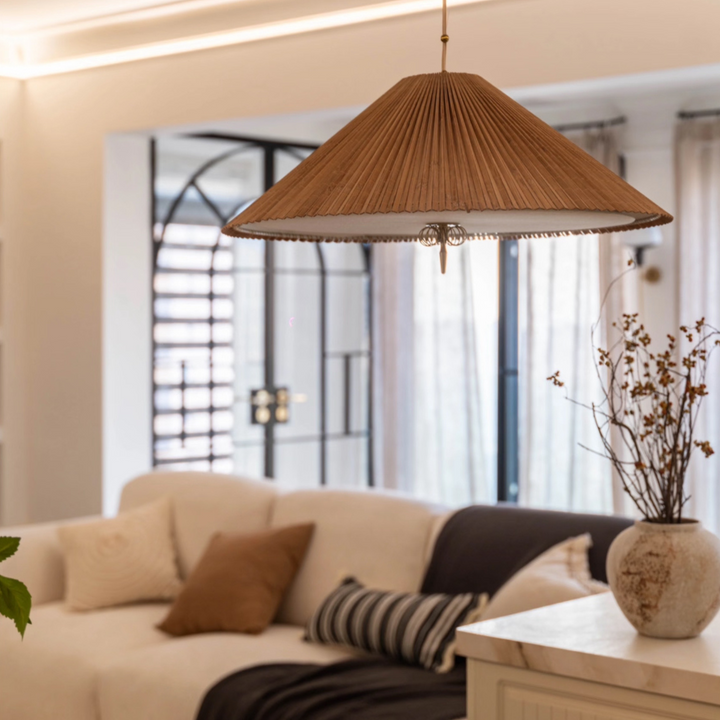 Organic pendant light above a sculptural dining setup in a calm interior