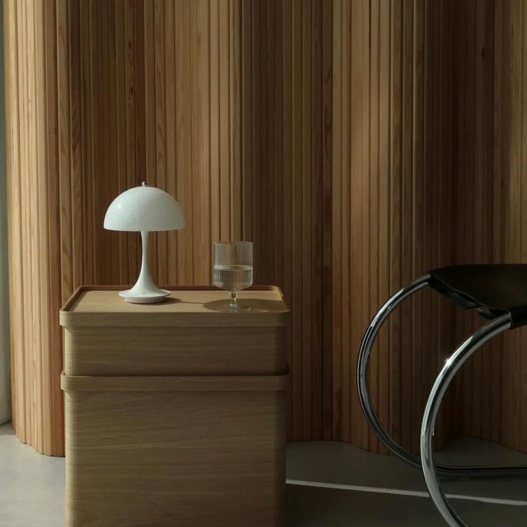 Modern bedroom decor with a sleek, portable table lamp that adds a calming atmosphere and functional design.