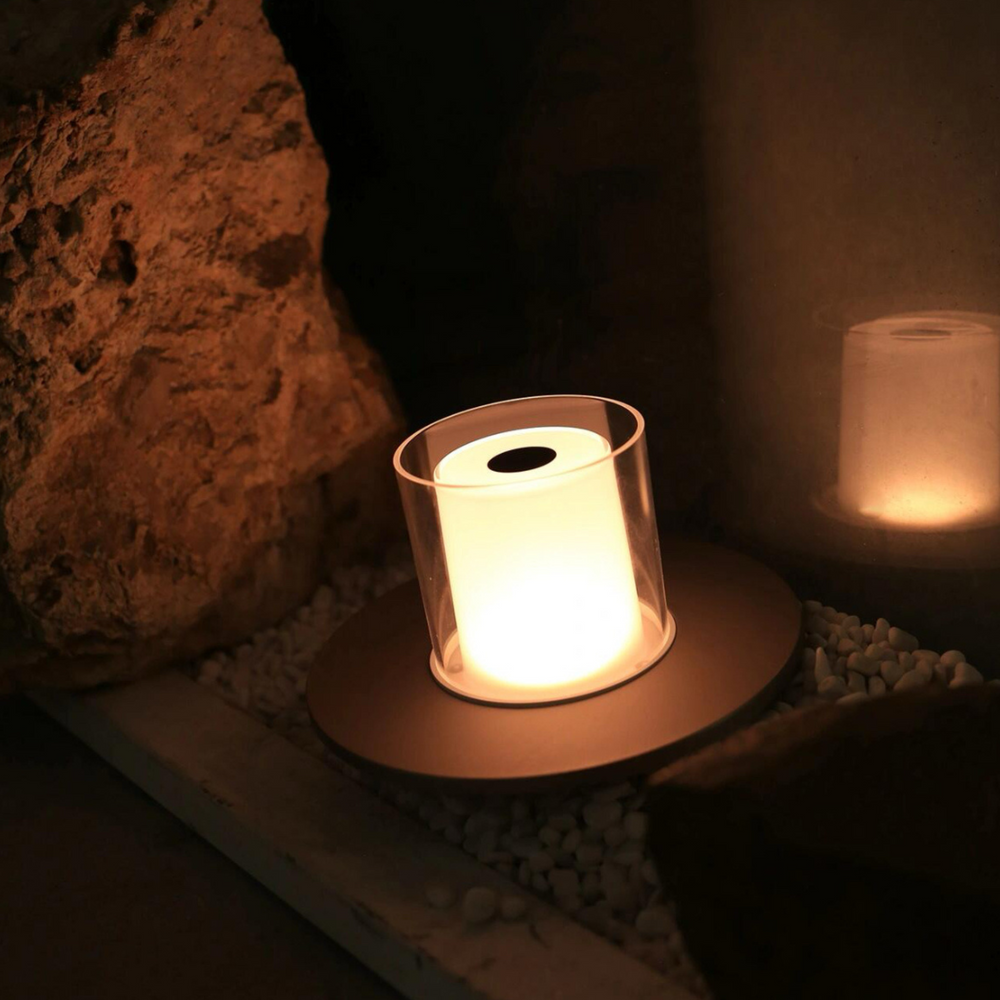 Modern candlelight lamp with sleek glass design, providing a warm glow in a cozy home setting.