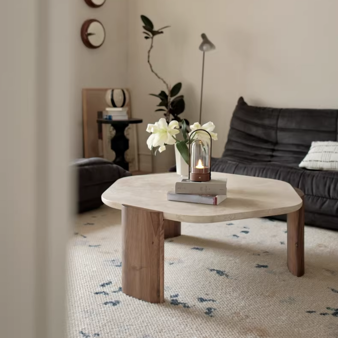 Modern coffee table with travertine top and oak legs in a contemporary living room