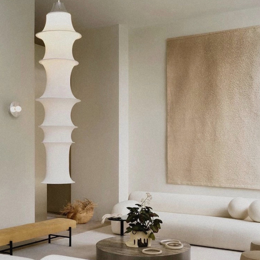 modern fabric pendant light hanging above a seating area in a calm minimalist living room.
