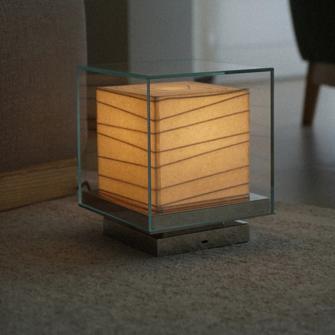 modern glass table lamp positioned low to the floor with warm diffused light.