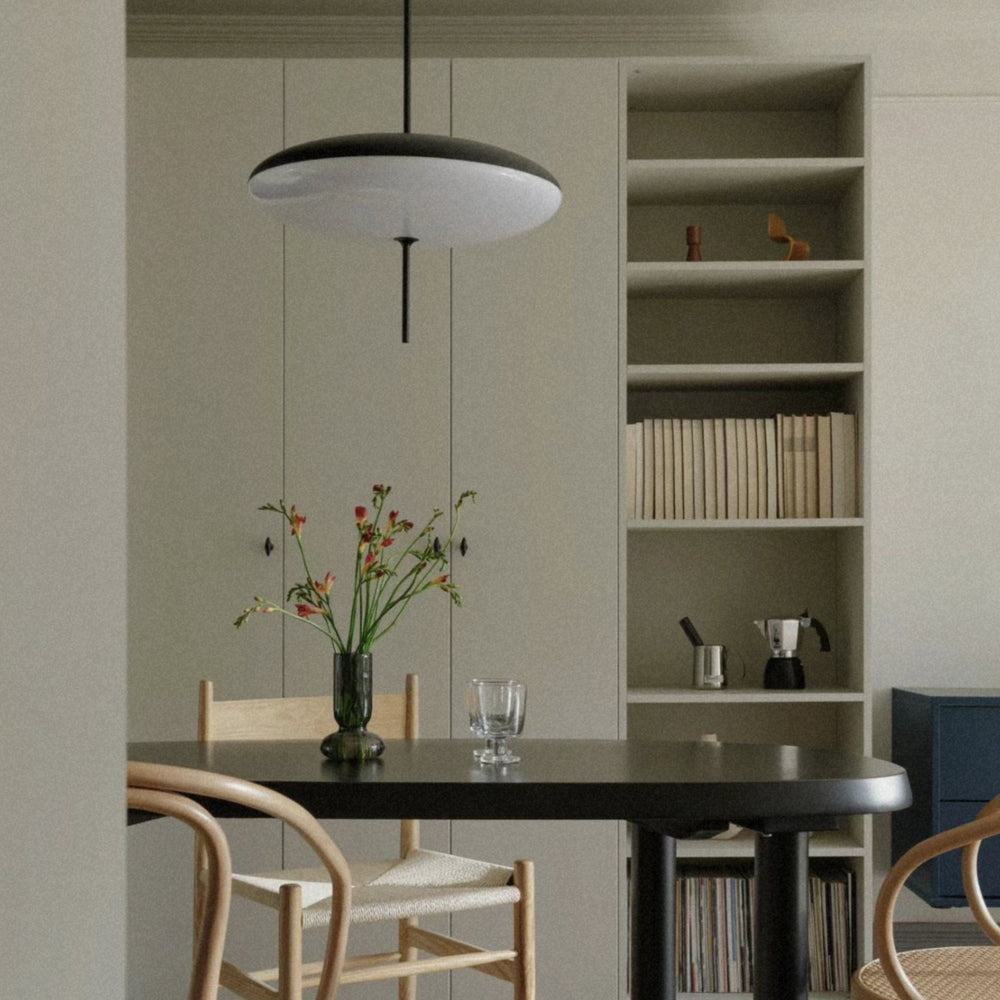 hanging light centered above a dining table in a minimal space.
