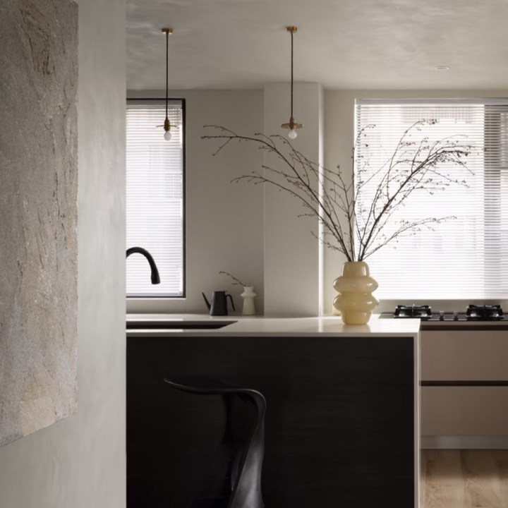 Modern kitchen interior with a stylish vase on the countertop, blending functionality and design.