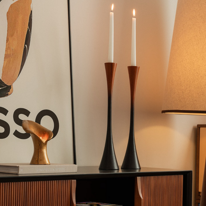 Wooden candle holders with gradient tones on a coffee table with soft neutral decor around.