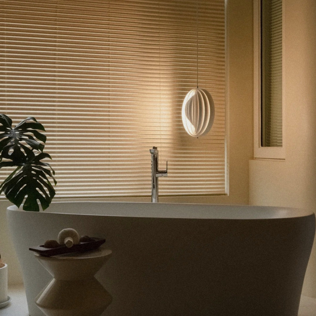 modern pendant light hanging near a bathtub with soft natural light.