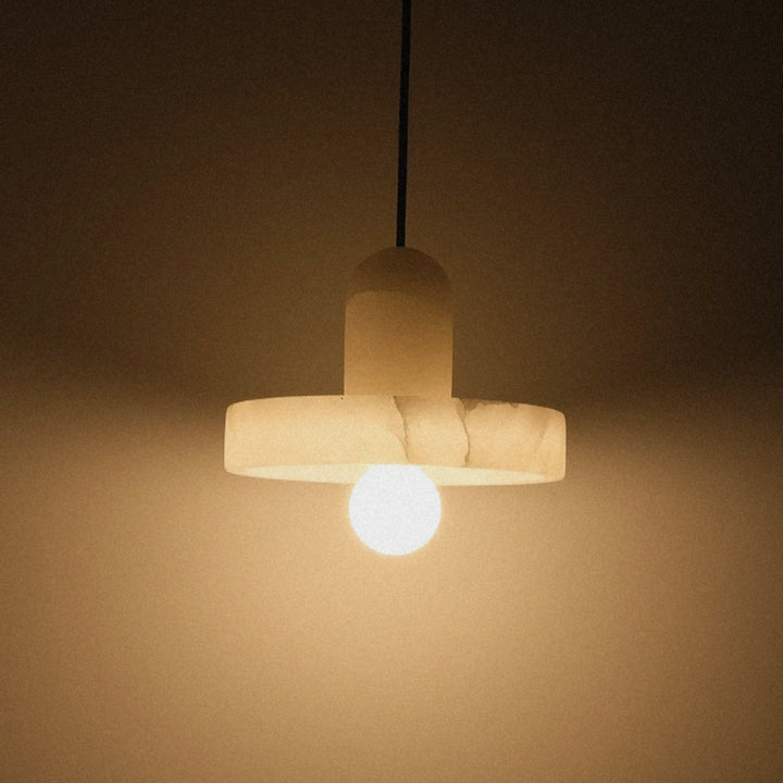 modern pendant light with a soft glow creating ambient lighting against a neutral wall.
