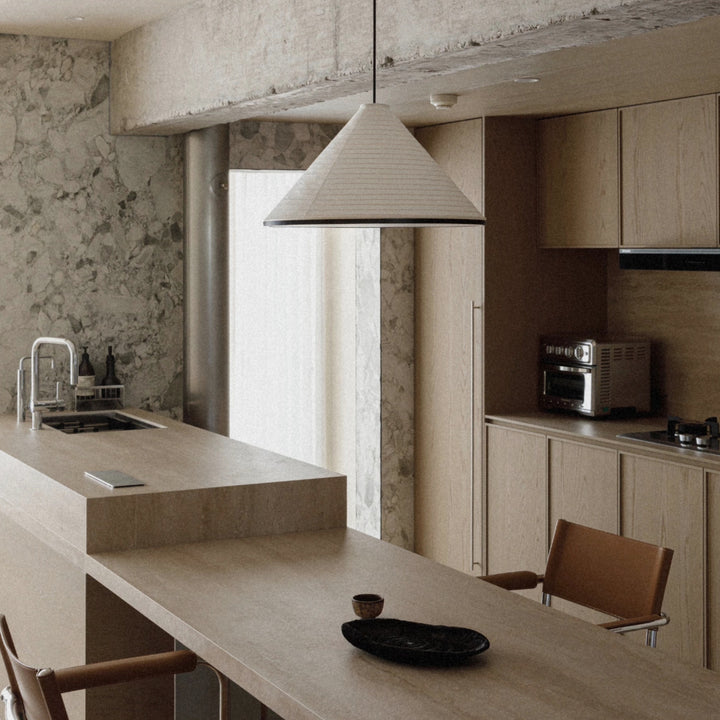 modern pendant light used above a kitchen counter in a warm interior.