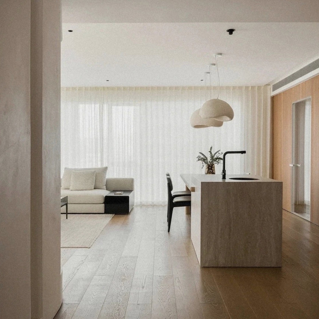 modern pendant light hanging above a kitchen island in an open space layout.