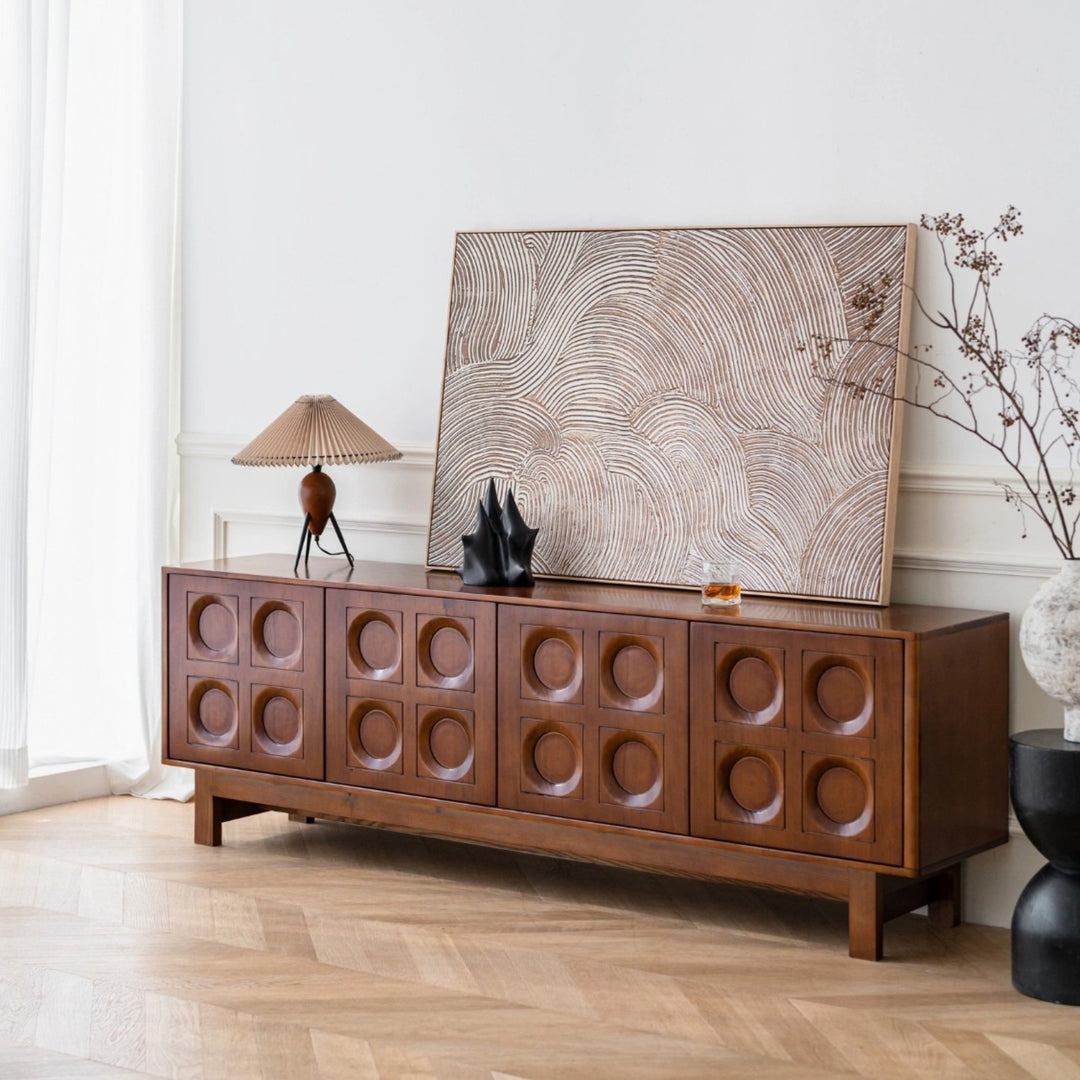 modern pleated lampshade table lamp styled on a wooden cabinet adding warm ambient lighting to a living room.
