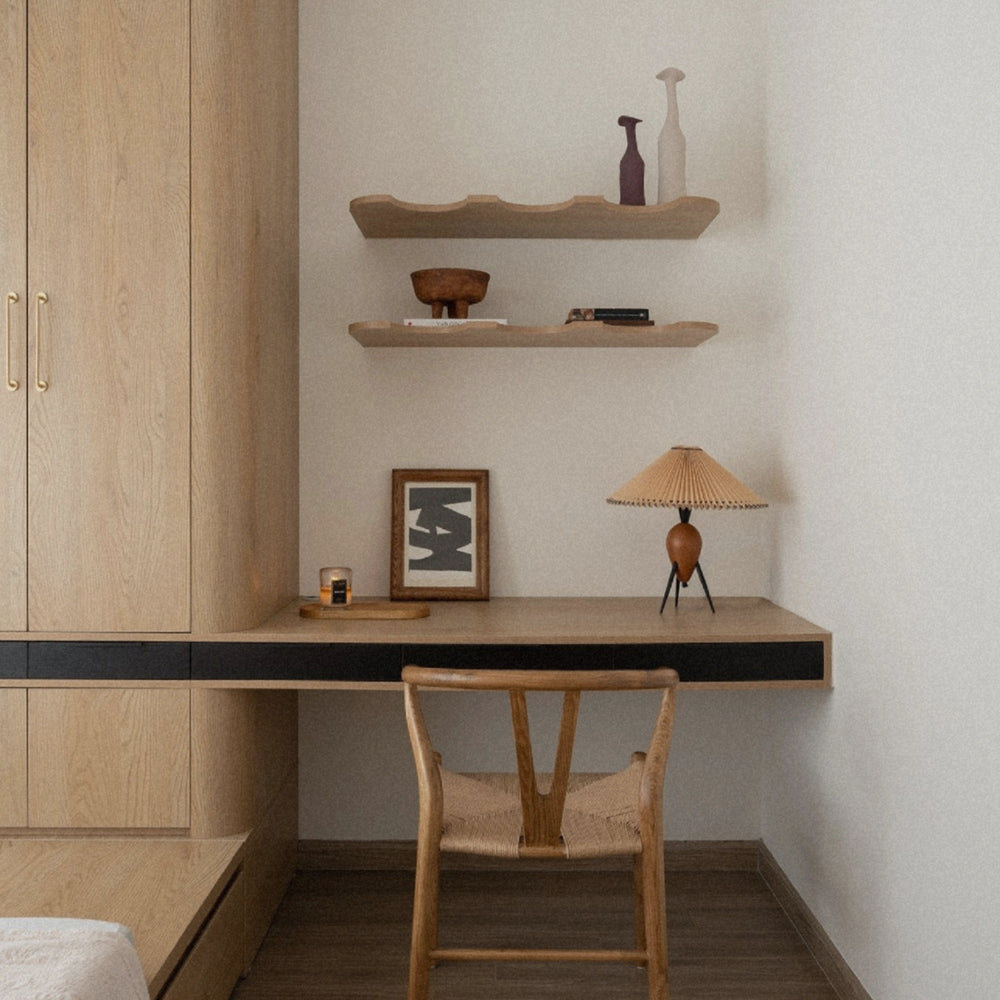 modern pleated table lamp positioned on a desk creating soft ambient lighting in a minimalist workspace.