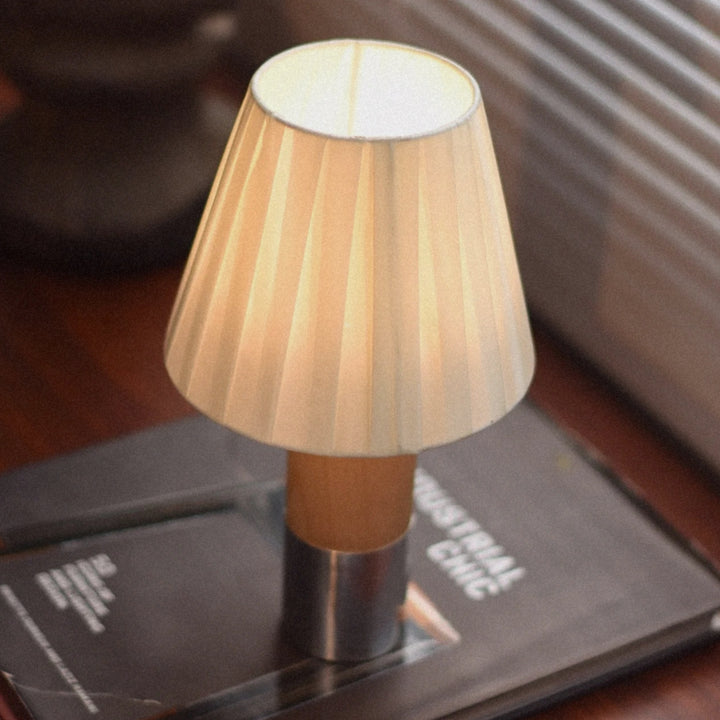 modern portable lamp providing ambient light on a dark wooden table.