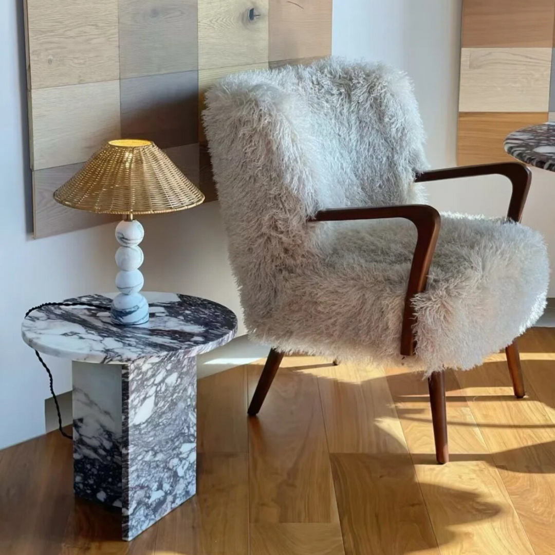 Minimalist rattan lampshade with a marble base styled beside a modern chair for a cozy touch.