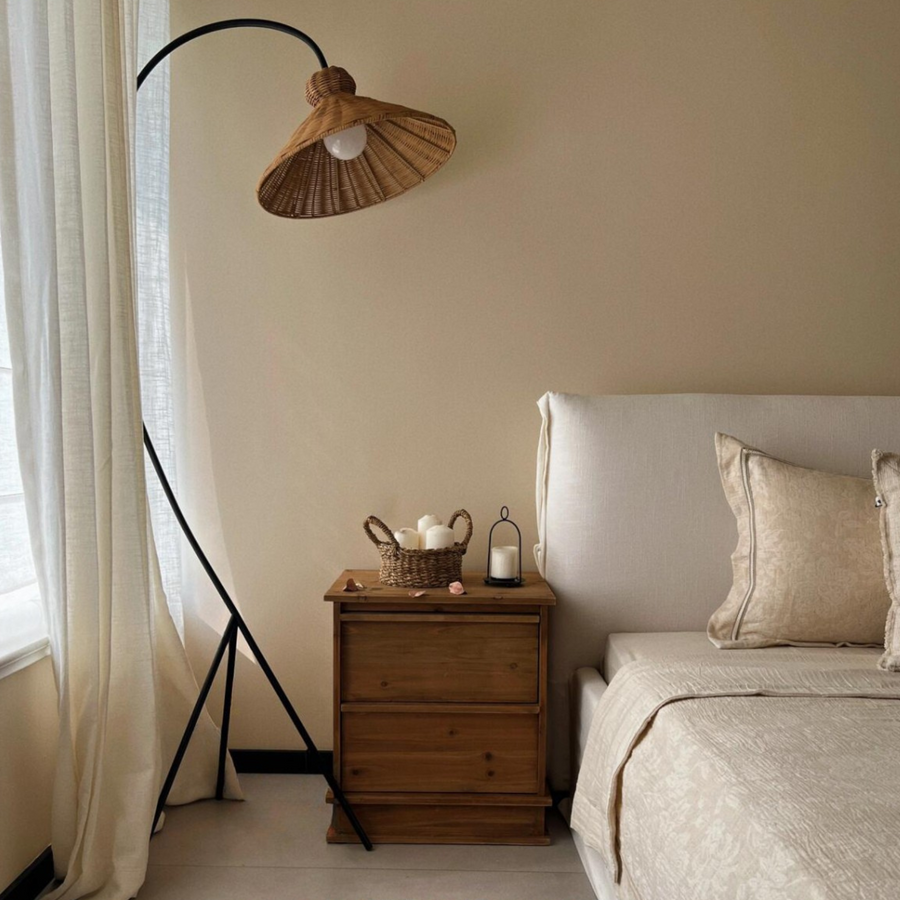 Modern bedroom with a stylish floor lamp featuring a rattan shade, complementing the minimalist decor.