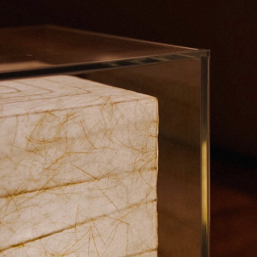 modern table lamp showing layered japanese paper texture inside a glass frame.