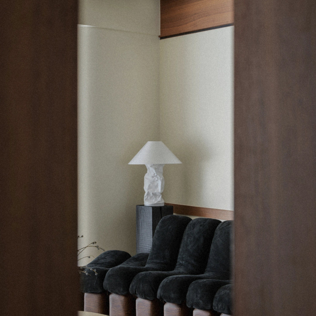 modern table lamp placed beside a lounge chair in a quiet seating area.