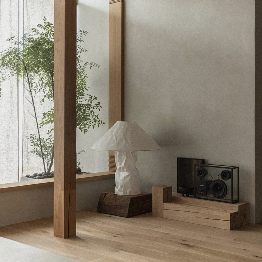 modern table lamp placed near a window on a low shelf in a calm interior.