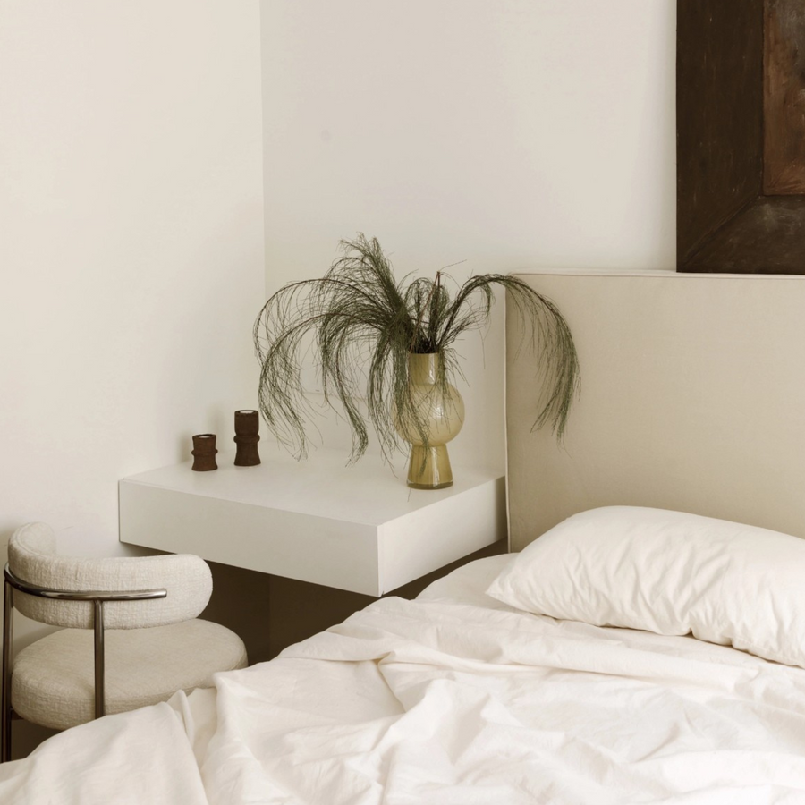 Modern bedroom decor accented with a fashionable vase beside the bed.