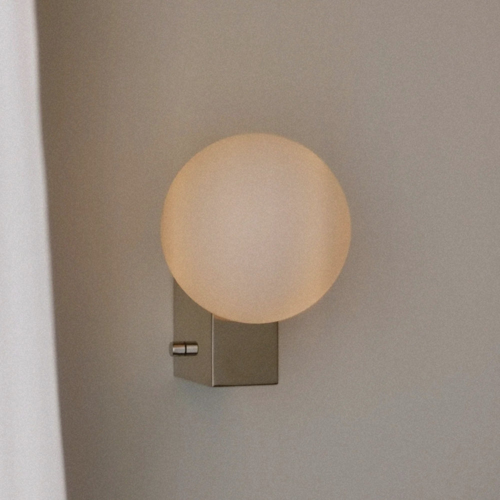 opal glass globe wall sconce attached to a square metal backplate.