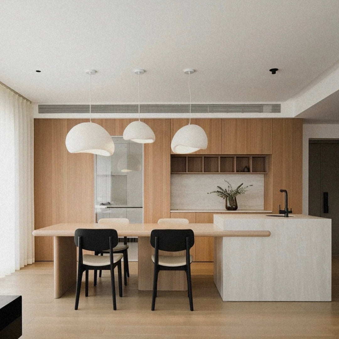 multiple pendant lights aligned above a kitchen island in a modern kitchen.