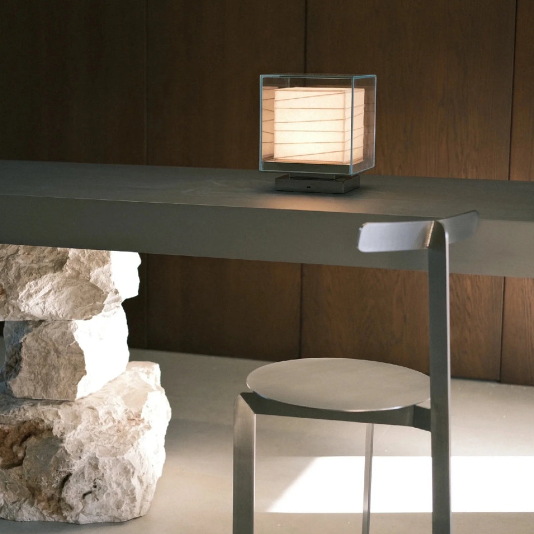 Nara table lamp on a minimalist desk with steel and natural stone base.