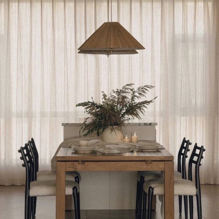 natural bamboo pendant light centered above a dining table bringing warm ambient lighting to a dining room.
