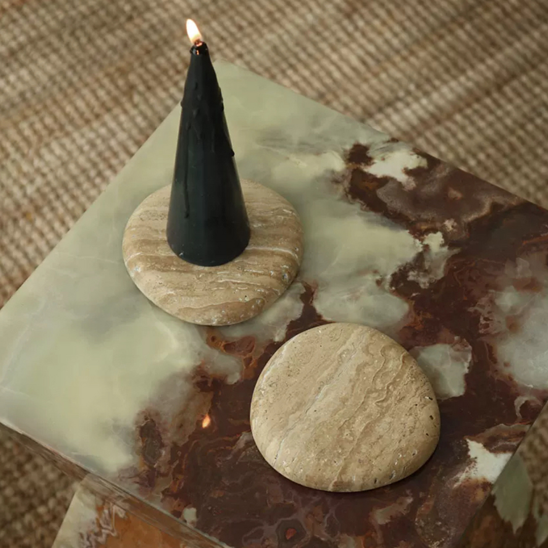 Natural brown marble coaster supporting a sleek black candle, enhancing home ambiance.