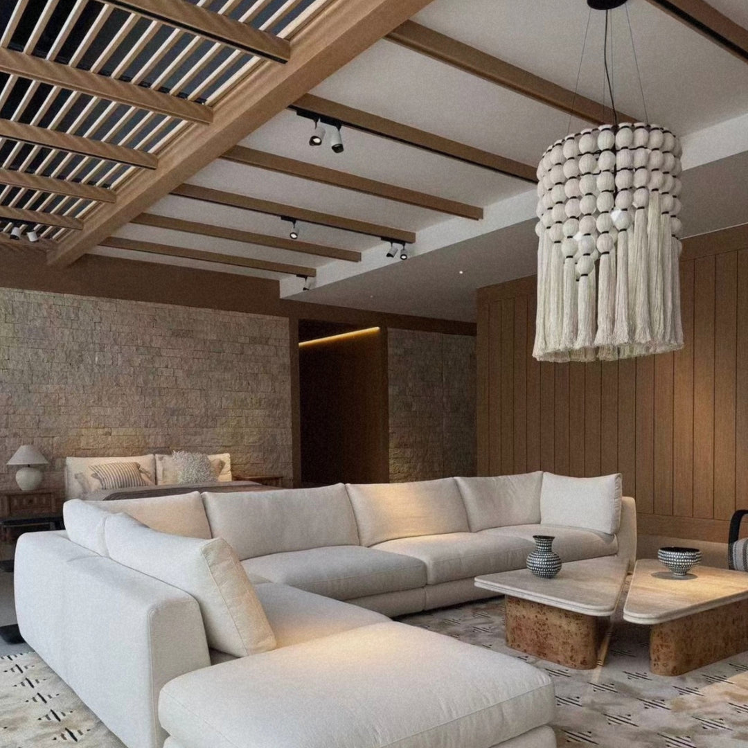 natural cotton pendant light hanging above a living room seating area in a calm contemporary interior.