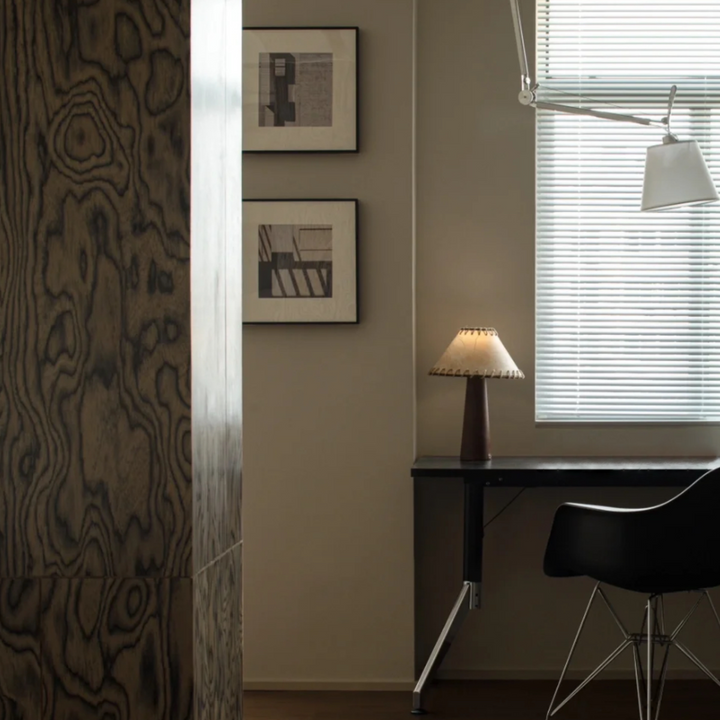 Close-up of a minimalist office desk with natural wood panel decor and warm lighting