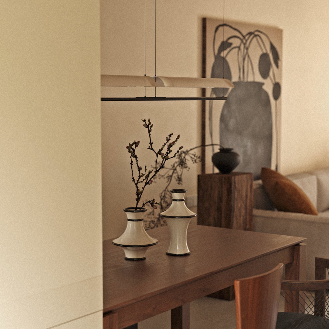 neutral ceramic decorative vases styled on a wooden console table in a warm japandi inspired living space.