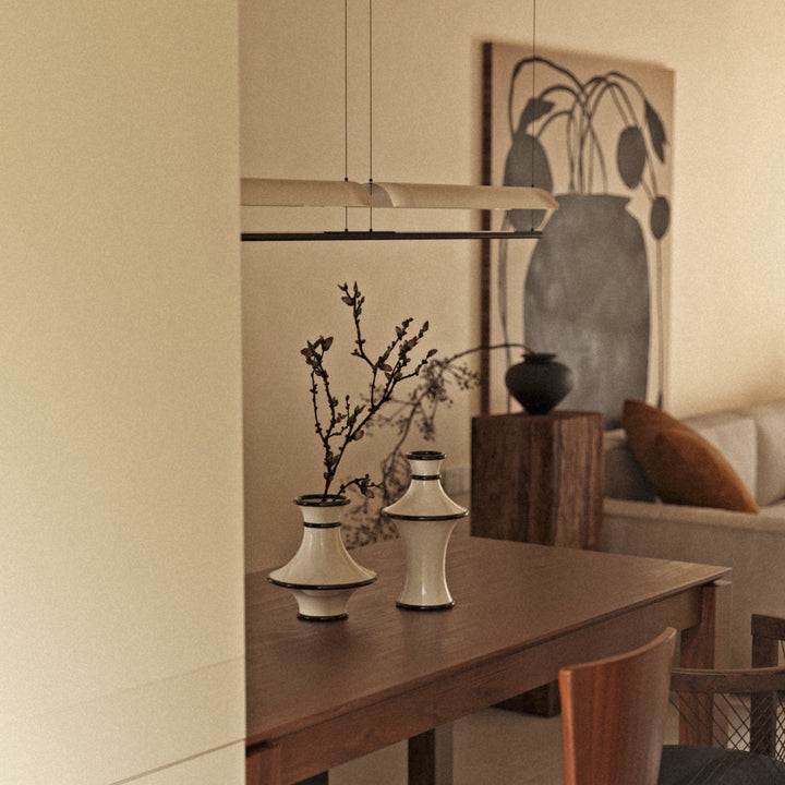 neutral ceramic decorative vases styled on a wooden console table in a warm japandi inspired living space.