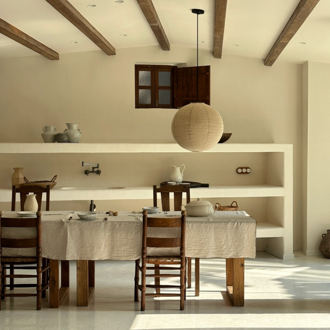 Neutral pendant light with cotton-linen texture above a Japandi dining table.