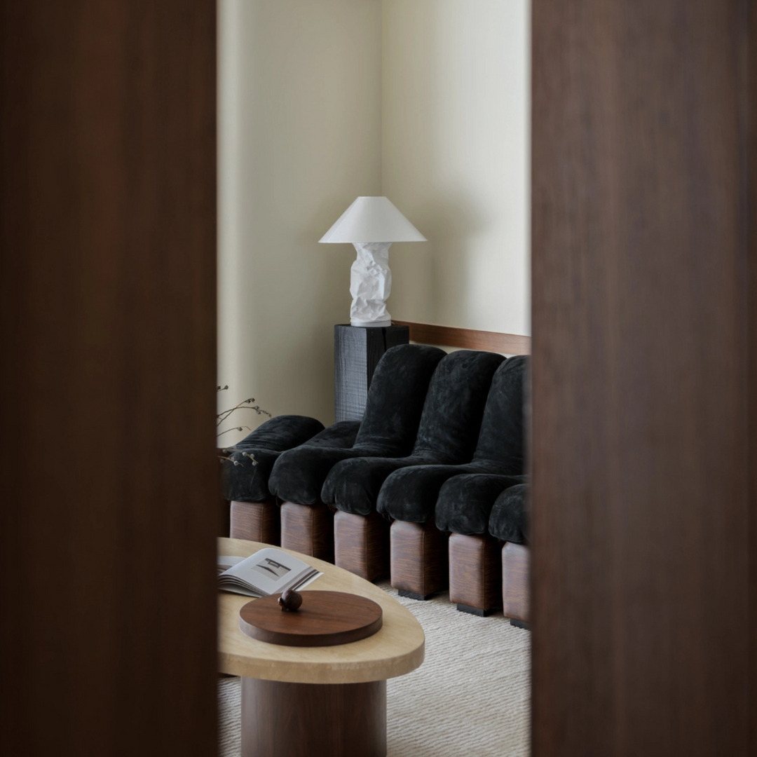 Neutral lighting with sculptural lamp in modern living room.