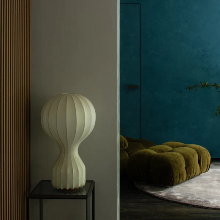 Neutral-toned table lamp styled in a calm space with deep blue and olive green contrast.