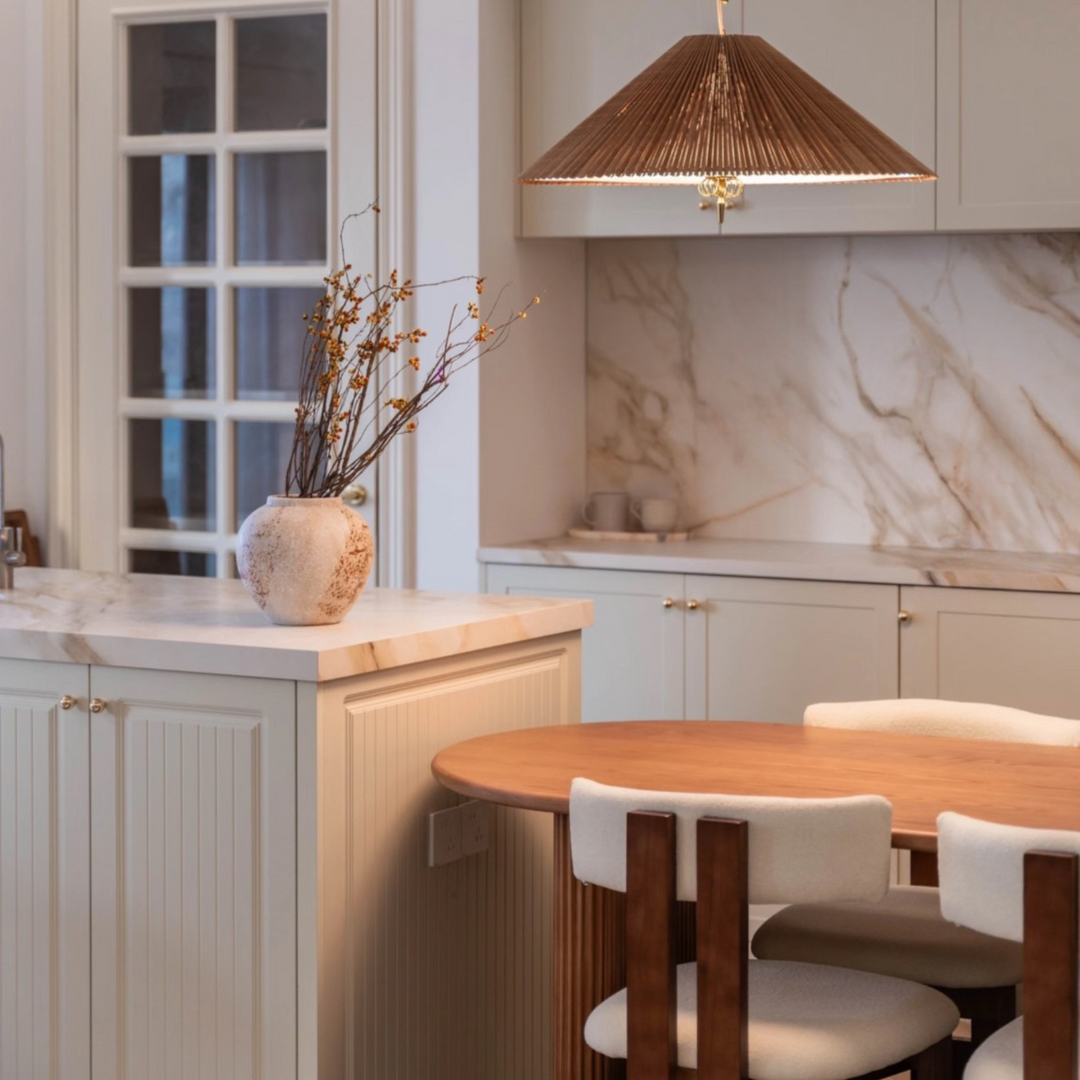Neutral-tone dining space styled with a woven pendant light and sculptural pieces