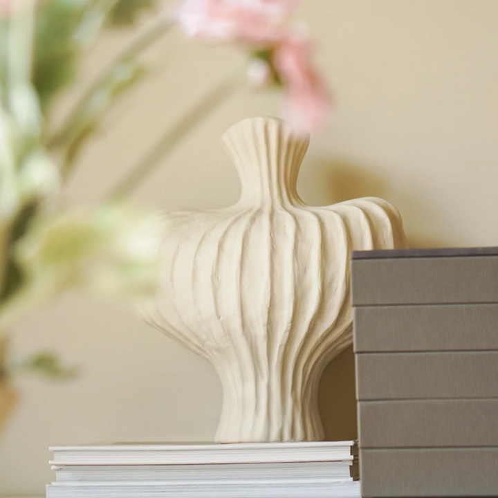 Neutral-toned ceramic vase with sculptural design, adding a soft touch to modern home interiors.