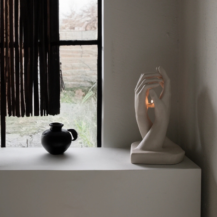 Sculptural candle holder placed by window in wabi-sabi decor