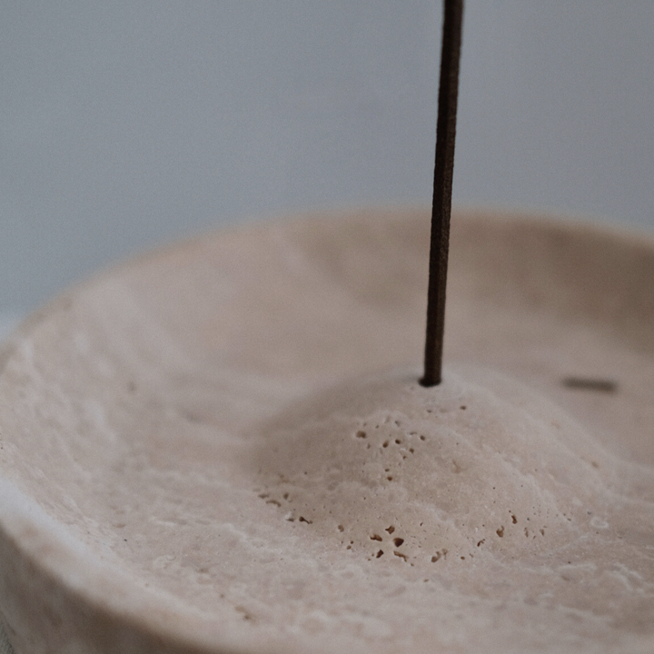 Travertine stone incense burner doubling as a tray, enhancing interior aesthetics.