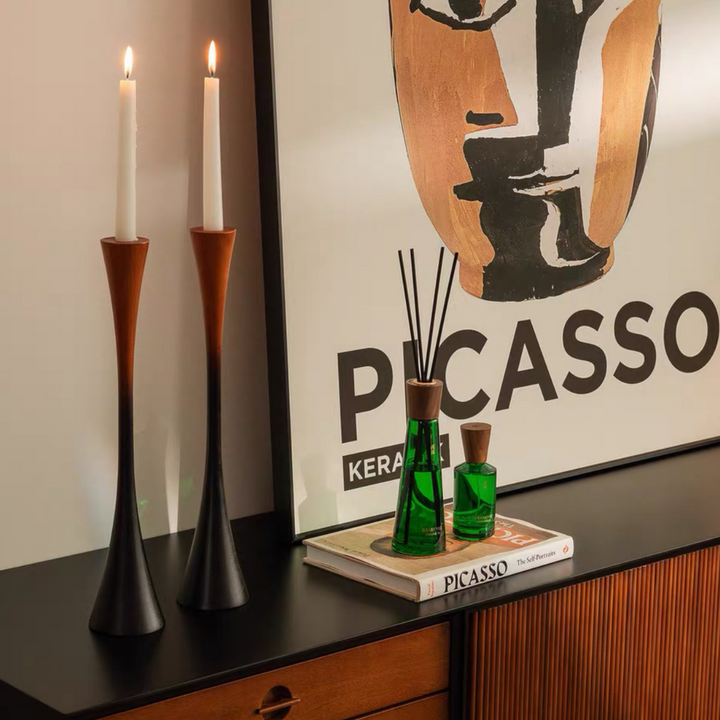 Sculptural candle holders with dark wood tones in a Japandi-inspired neutral living space.