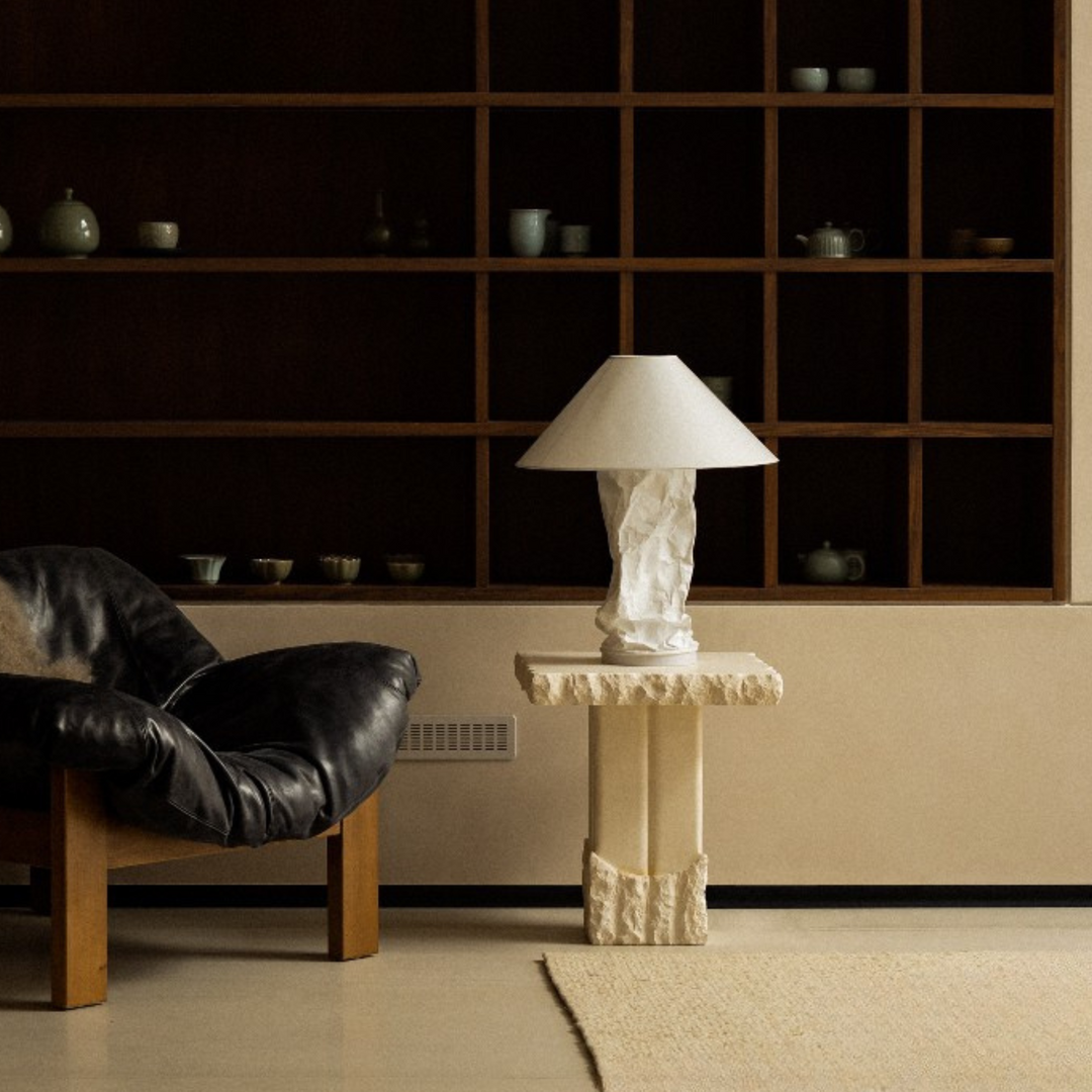 Organic modern lamp placed on natural stone pedestal.