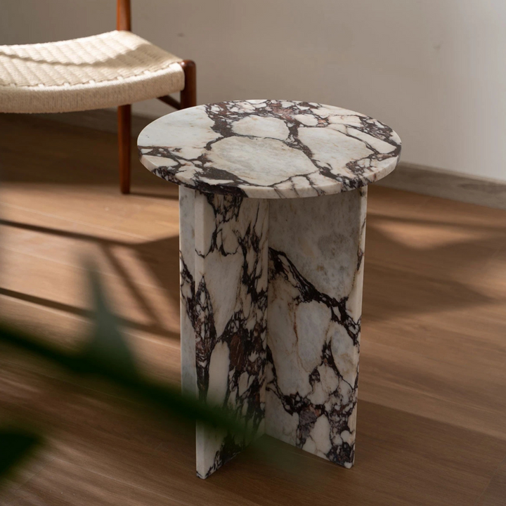 Organic modern marble coffee table in soft neutral interior with natural wood flooring