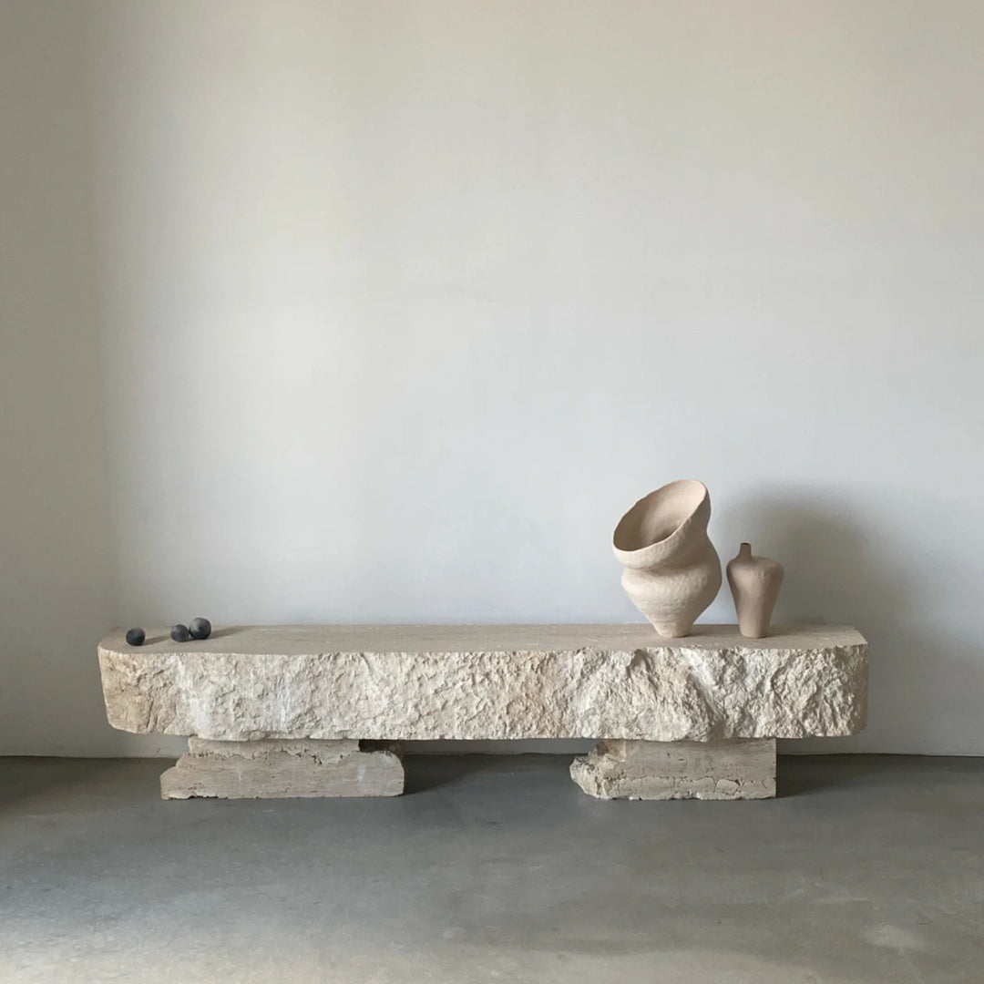 Organic modern vase displayed on a sculpted natural stone bench.