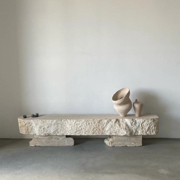 Organic modern vase displayed on a sculpted natural stone bench.